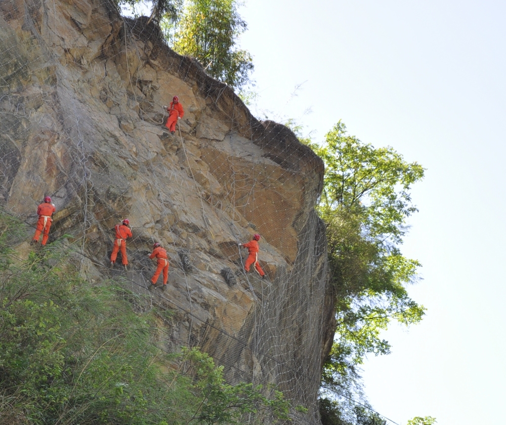 4.20地震后，四川路桥抢险队员在悬崖上安装防护网